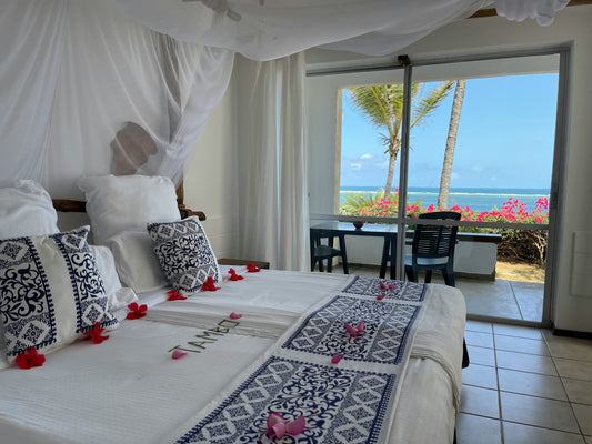 Pristine white hotel bed linen and folded towels in a Zanzibar boutique hotel room — Atlas Hospitality Supply, Zanzibar's hospitality textile specialist