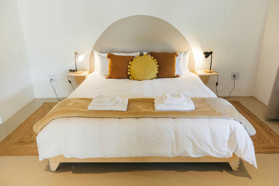 Perfectly made hotel bed with crisp white Egyptian cotton linen and folded towels in a Zanzibar boutique hotel — Atlas Hospitality Supply